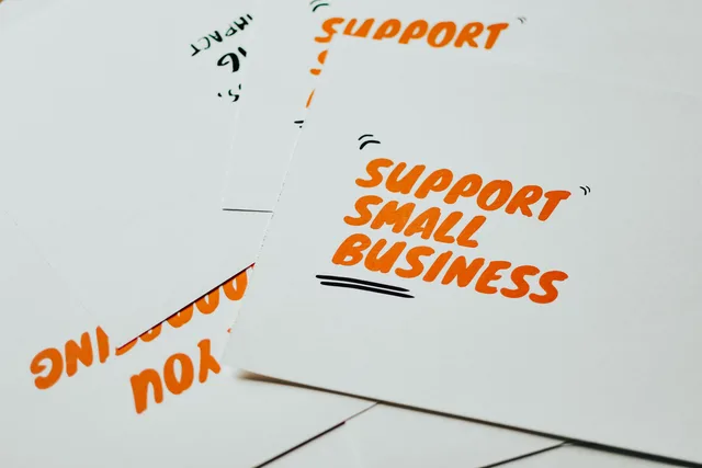 Close-up of motivational cards promoting support for small business on white background. Scottish Enterprise and Business Wales grants, what differs for small firms